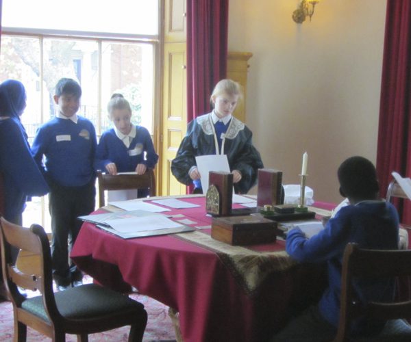School children stood around a Victorian table